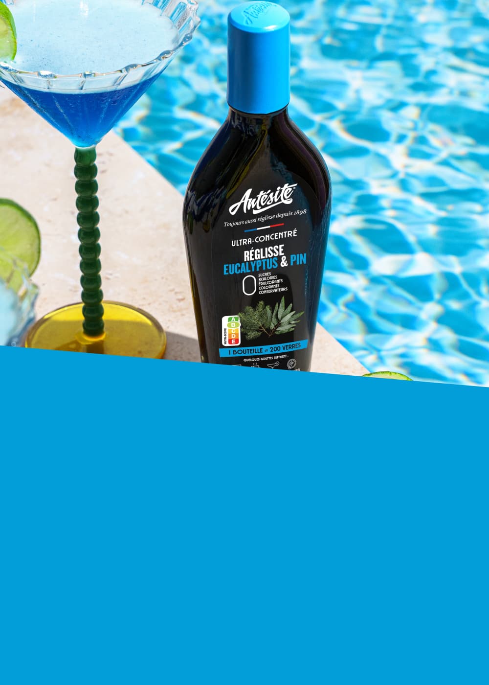 Antésite Réglisse Eucalyptus et pin à côté d'une piscine et d'un cocktail bleu