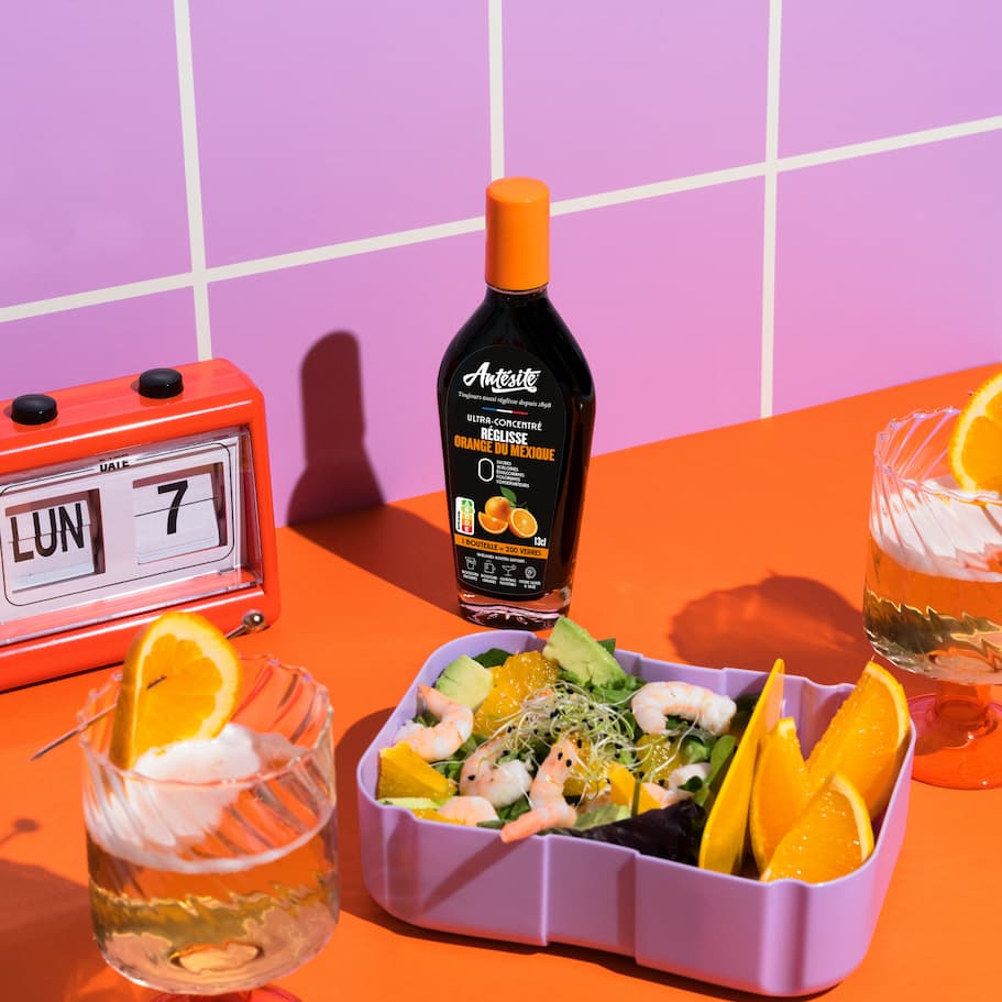 Antésite Orange du Mexique à côté d'une salade avec des fruits et deux boissons avec de l'orange