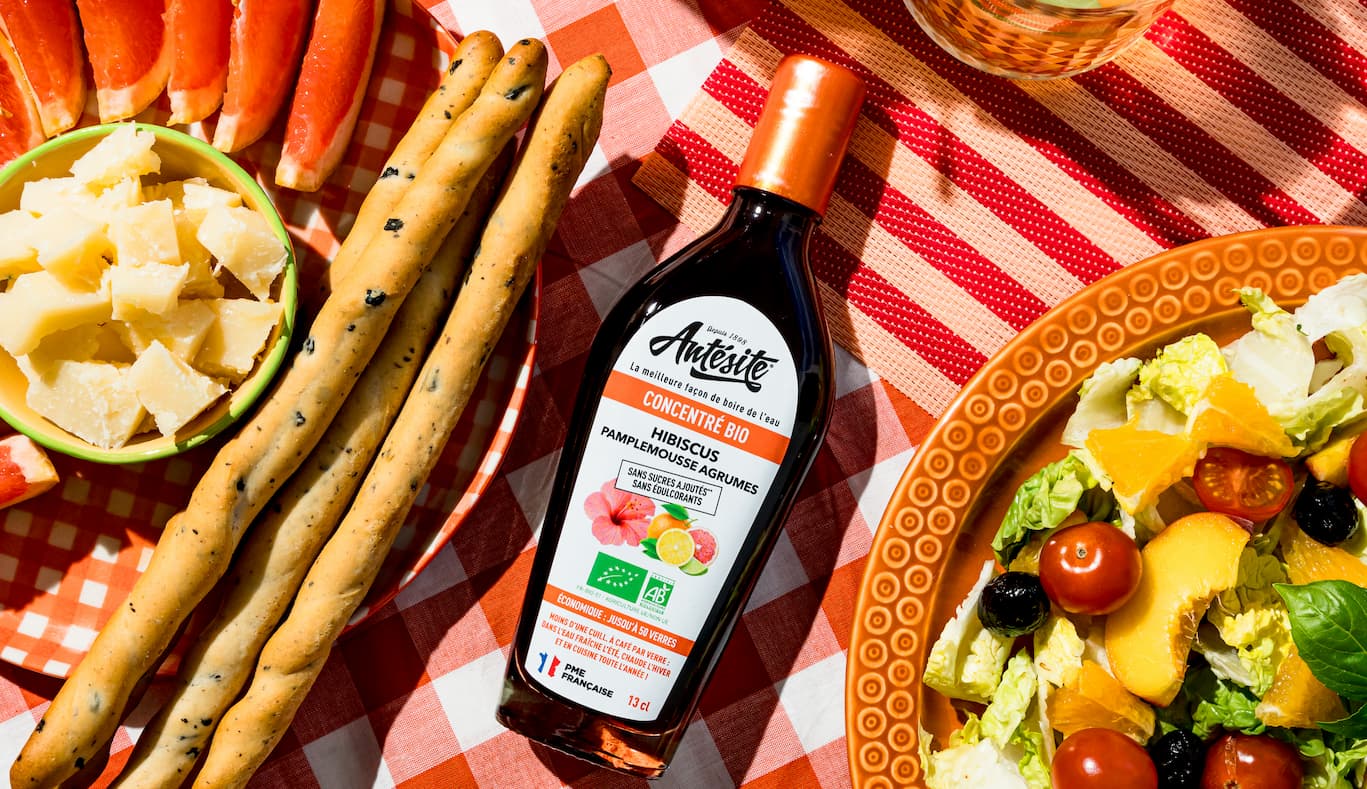 Antésite Hibiscus Pamplemousse agrumes sur une table avec une salade et des fruits